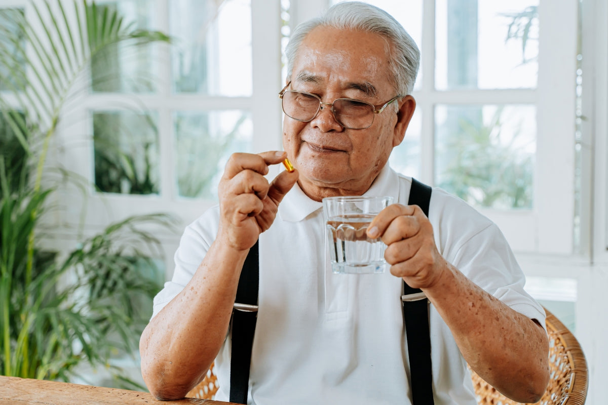 Elderly man taking a Nattokinase supplement.