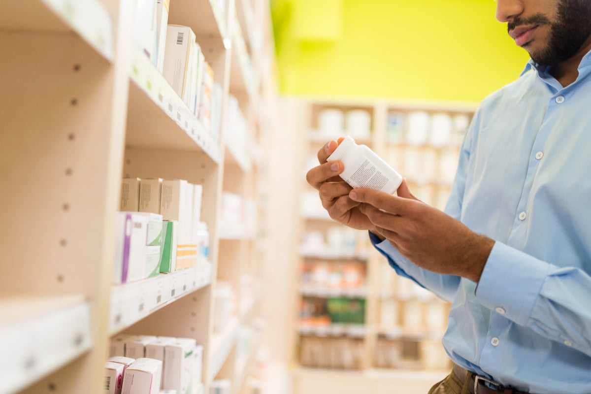 Man inspecting a heart health supplement bottle.