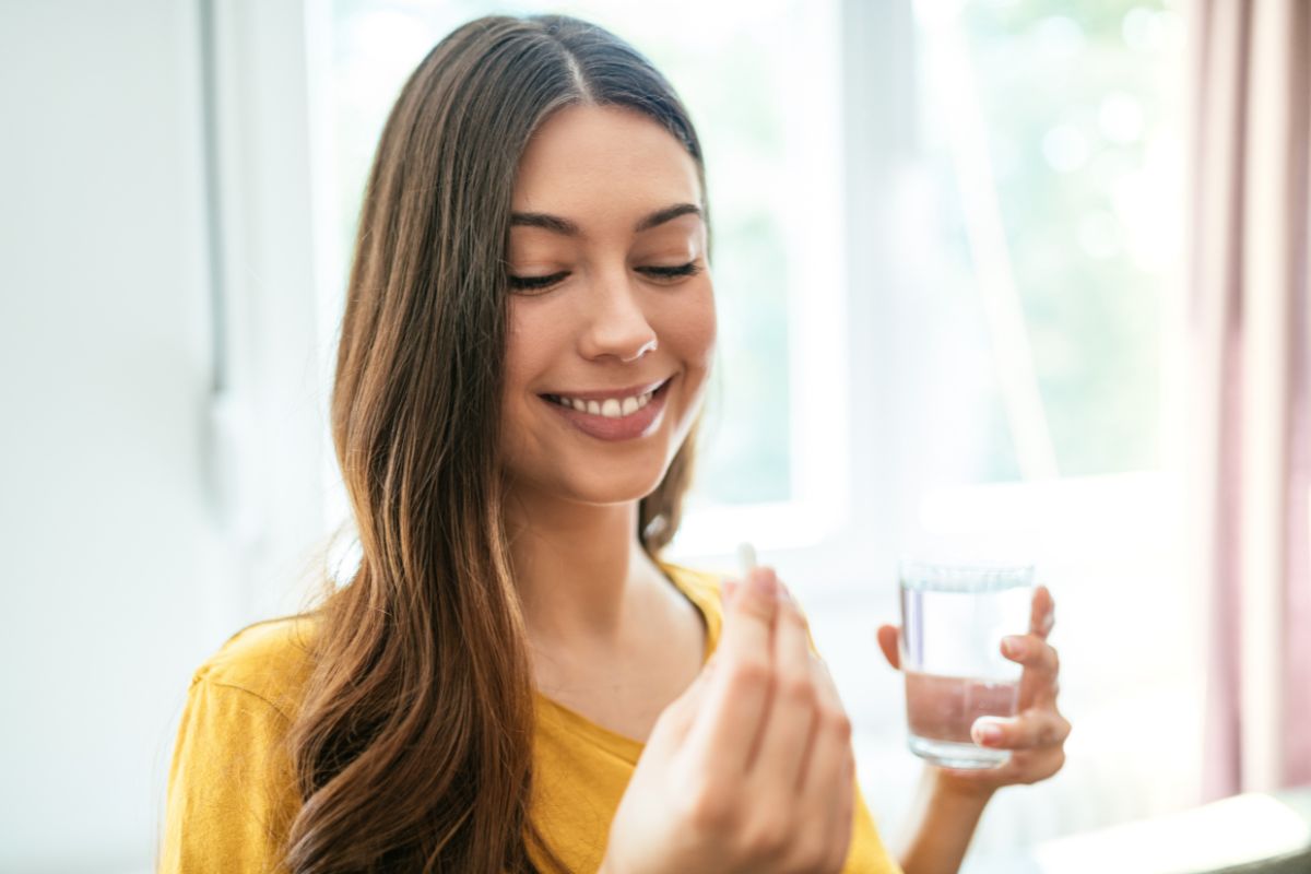 Woman drinking daily skin probiotic supplement