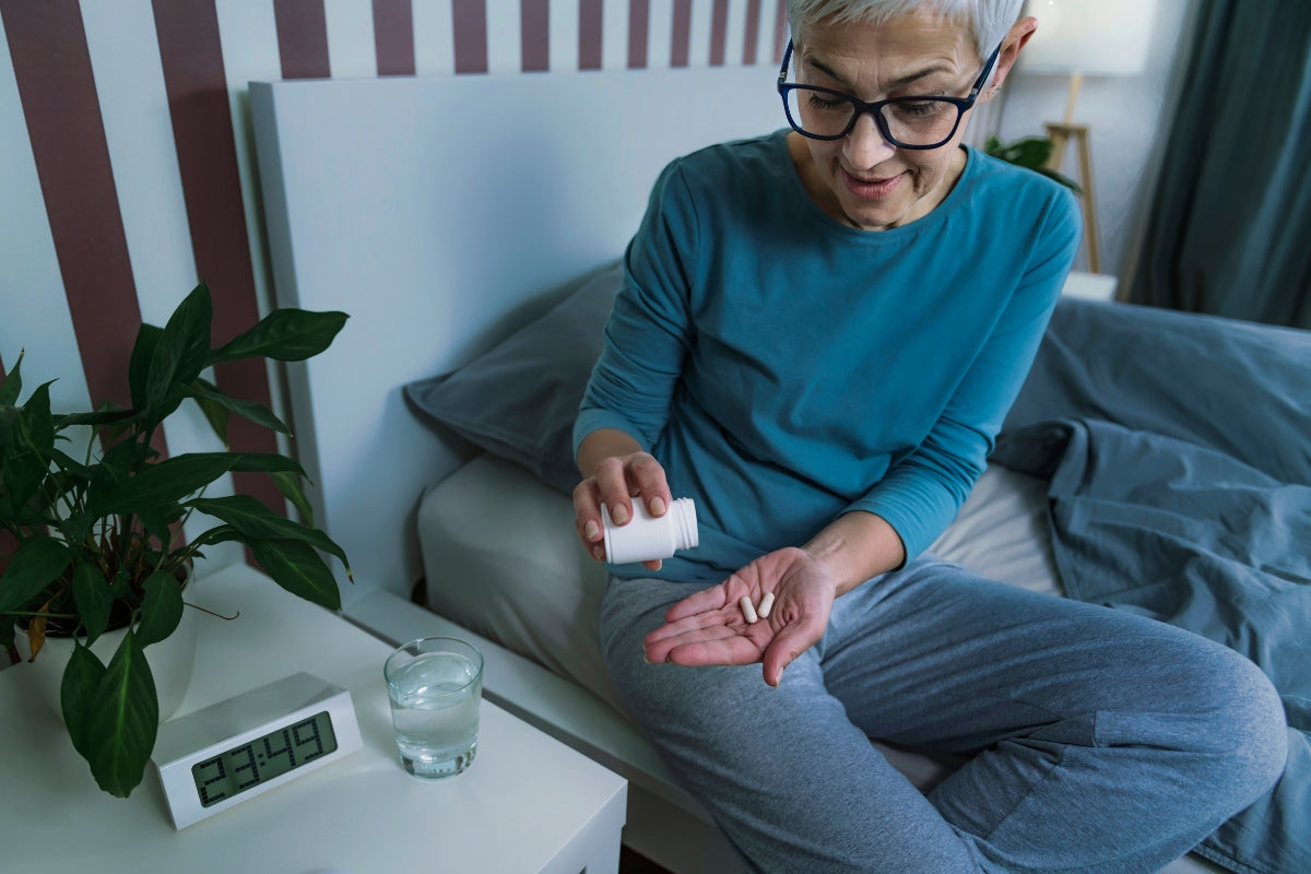 An elderly woman taking a daily supplement for heart health.