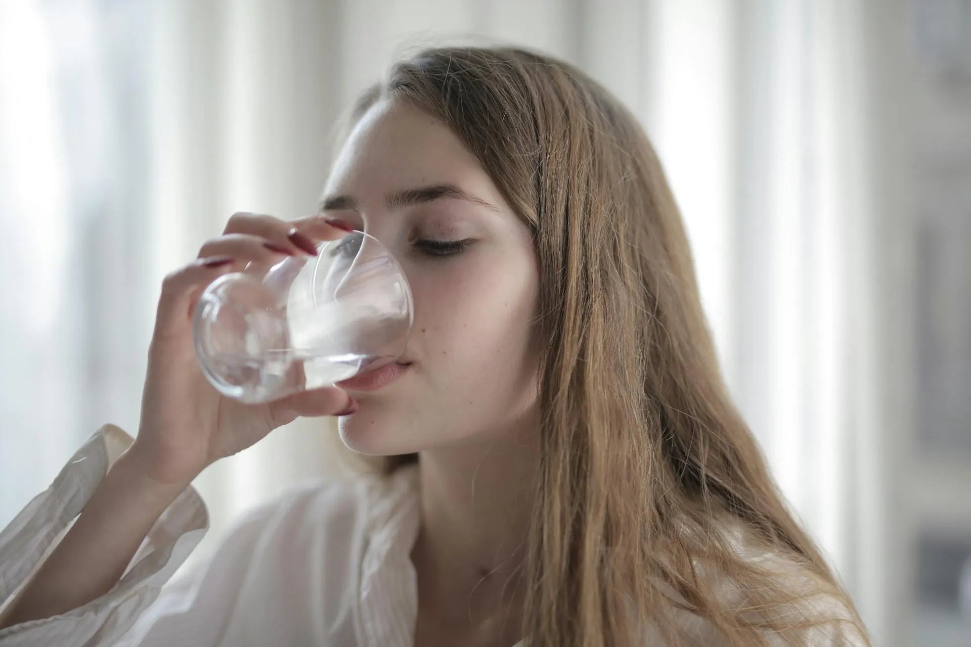 a woman drinking a glass of water 