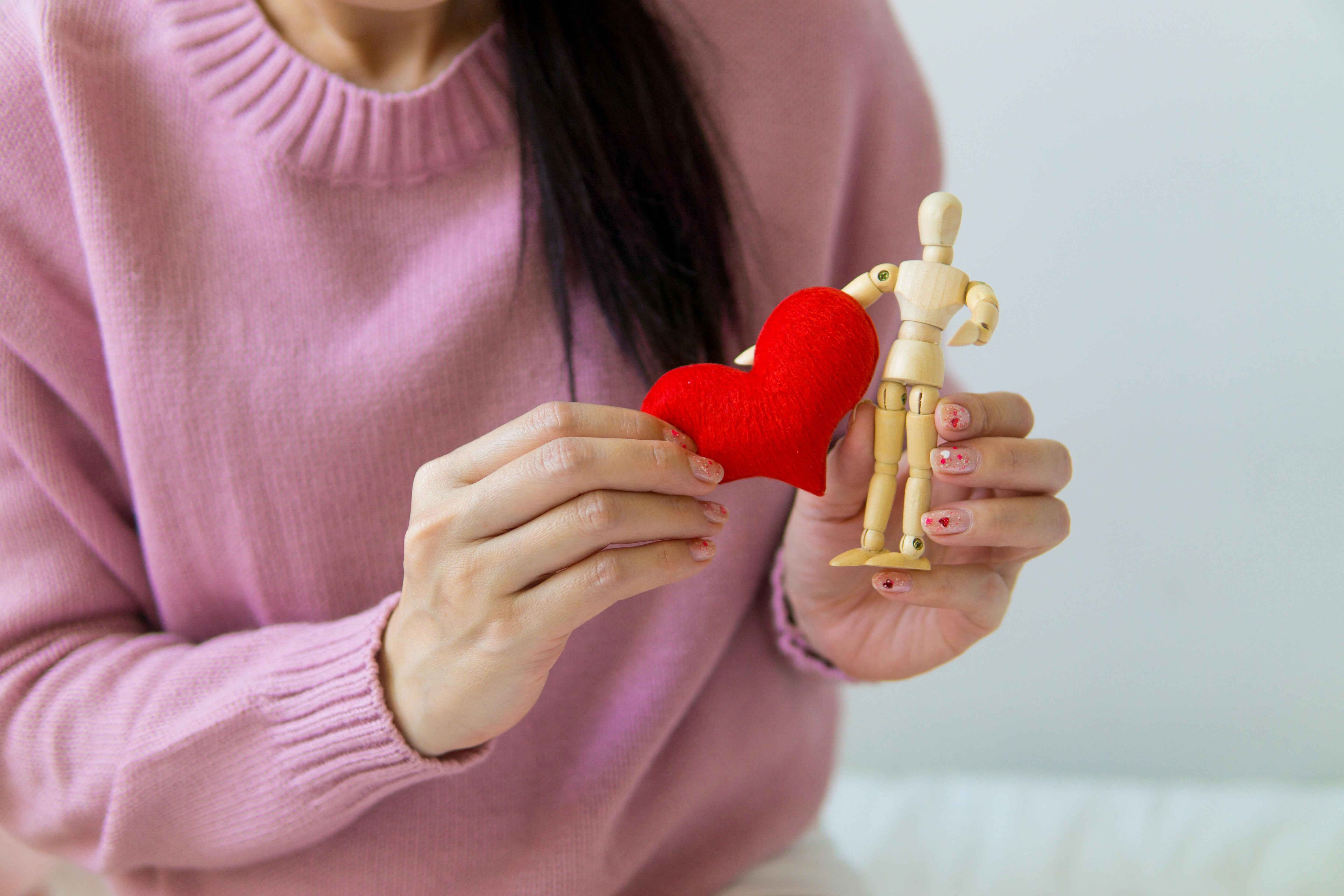 a woman holding a heart and human replica